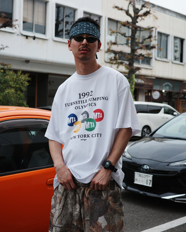 ANACHRONORM × Souvenyr NYC ジャンピング 半袖Tシャツ ホワイト | コラボグラフィック ニューヨーク コットン100%