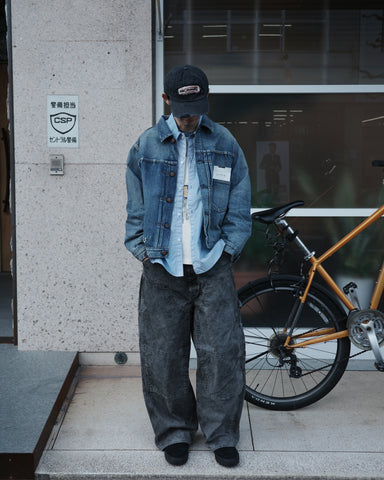 70502XX 1stタイプを現代的に再構築したデニムジャケット。12.5ozセルビッチデニムを使用し、5年間の激しい着用を想定したエイジングを施しました。精巧なダメージリペアと最終工程の汚し加工を加えることで、中濃色のブルーに圧倒的なリアリティを注入。ヴィンテージの風格を纏いつつ、クリーンなシルエットが光るリメイクモデルです。
A refined denim jacket based on the 70502XX 1st type, made from 12.5oz selvedge denim. The "Five Year" finish features heavy fading and bold wear, enhanced by meticulous repairs and a final "dirt" tint for a realistic vintage feel. 