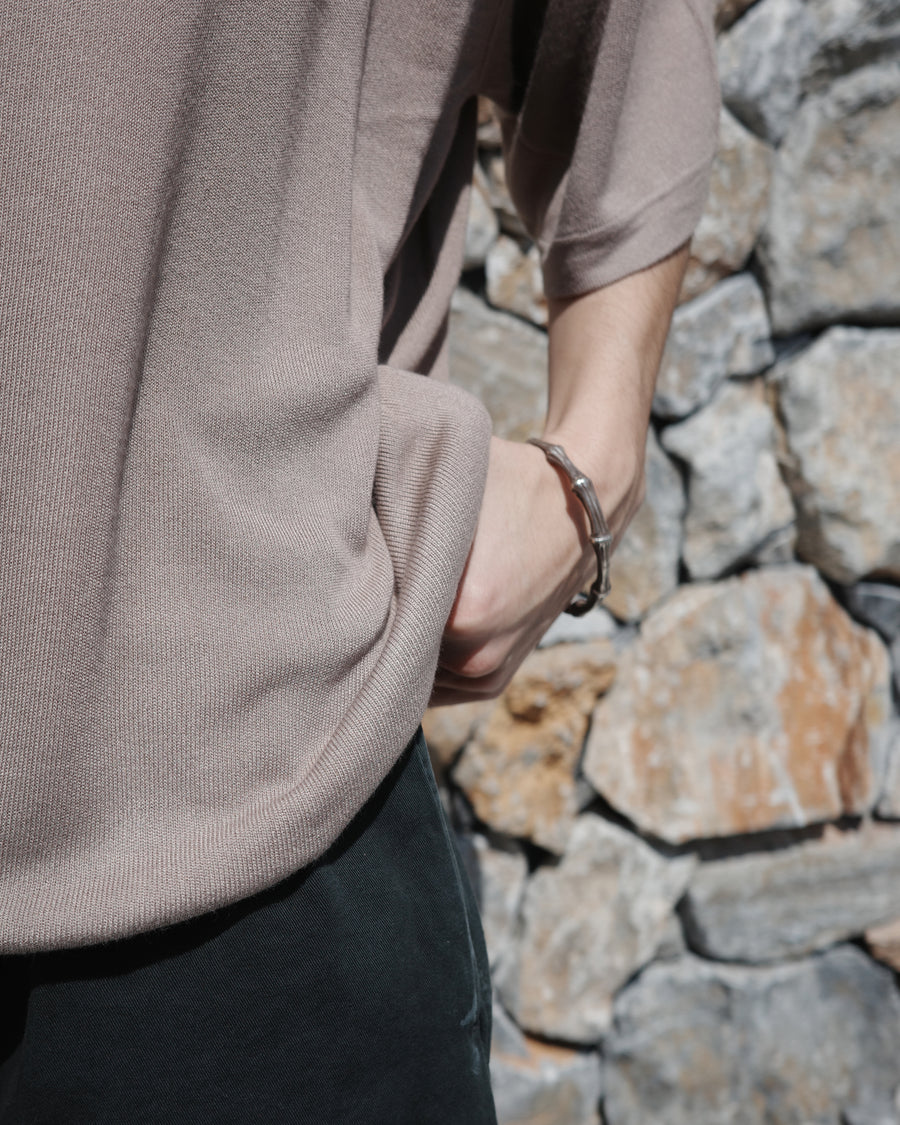 ディテールを極限まで削ぎ落とし、着心地とシルエットを追求したニットTシャツ。気候変化に対応する新たなアプローチとして、軽量で吸水・放湿性に優れた竹（バンブー）素材を採用しました。滑らかでとろみのある肌触りと、袖を通した瞬間に感じる清涼感は格別です。家庭洗濯も可能で、日常に圧倒的な心地よさを提供します。

A minimalist knit T-shirt focused entirely on fit and comfort. Crafted from bamboo yarn, this lightweight, durable material offers exceptional moisture absorption and a refreshing cool-to-the-touch feel. This LIGHT BEIGE piece features a silky, fluid drape that provides overwhelming comfort, perfect for changing climates, and is conveniently home-washable.