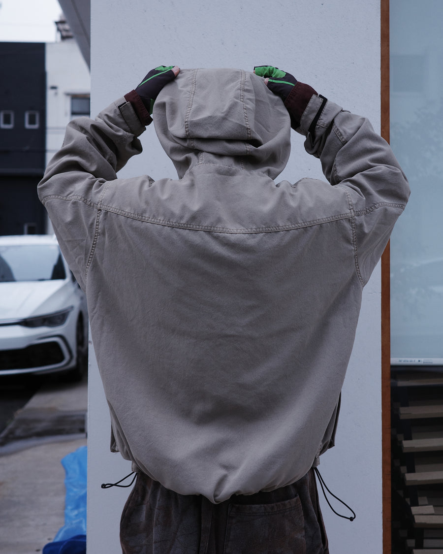 ポリエステル100％でありながら、綿のような質感と軽量性を備えた高機能な一着。タスラン加工糸を使用したポリエステルオックスを採用し、シワになりにくく速乾性に優れたイージーケア性を実現しました。本来染色が困難な素材に特殊顔料染めを施すことで、化繊特有の光沢を抑えた、ナチュラルで奥行きのある絶妙なフェード感を表現しています。

A high-performance piece crafted from polyester oxford, offering a cotton-like touch with lightweight, quick-dry, and wrinkle-resistant properties. This GRAY BEIGE item features a special pigment dye—a rare process for polyester—achieving a sophisticated, faded texture and a matte finish that defies its synthetic origins.