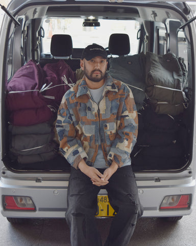 日本古来の伝統技法「刺し子」をANACHRONORMの独自の背景で表現。6ozナチュラルスラブデニムをベースに、インディゴやシャンブレーなど数種類の生地を刺し縫いし、職人の技術が集約したスペシャルな一着に仕上げました。特殊エイジング加工により、限界まで柔らかくした質感と手作業によるダメージ、さらに一点一点丁寧に色を乗せることで、唯一無二の奥行きある表情を引き出しています。Inspired by traditional Japanese "Sashiko" embroidery, this jacket is a masterpiece of craftsmanship. Built on a 6oz natural slab denim base with various indigo and chambray patches, it undergoes a complex aging process. Each piece is hand-distressed for maximum softness and meticulously hand-colored, resulting in a unique,