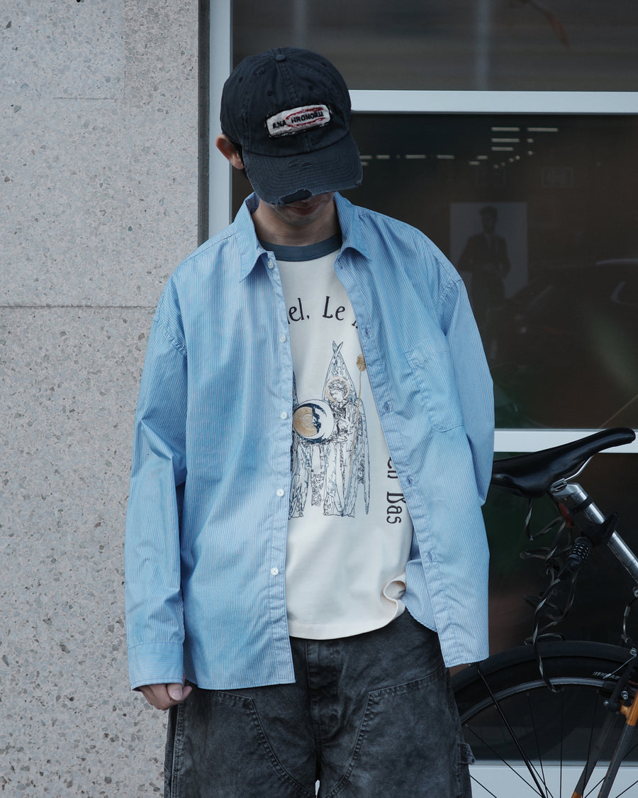 クリーンな高密度ストライプシャツに、スプレーによる顔料吹き付け加工を施し、自然なムラ感を与えた一着。リラックス感のあるシルエットが、上品さとラフさを絶妙なバランスで両立させています。素材には米綿100%の高密度ストライプ生地を採用。綿100%のナチュラルな風合いながら、シワになりにくい実用性も兼ね備えています。

A clean stripe shirt enhanced with a subtle pigment spray process for a natural, textured look. The relaxed silhouette perfectly balances elegance with a casual edge. Crafted from high-density US cotton stripe fabric, this BLUE STRIPE piece offers a crisp feel that is naturally wrinkle-resistant while maintaining the comfort of 100% cotton.