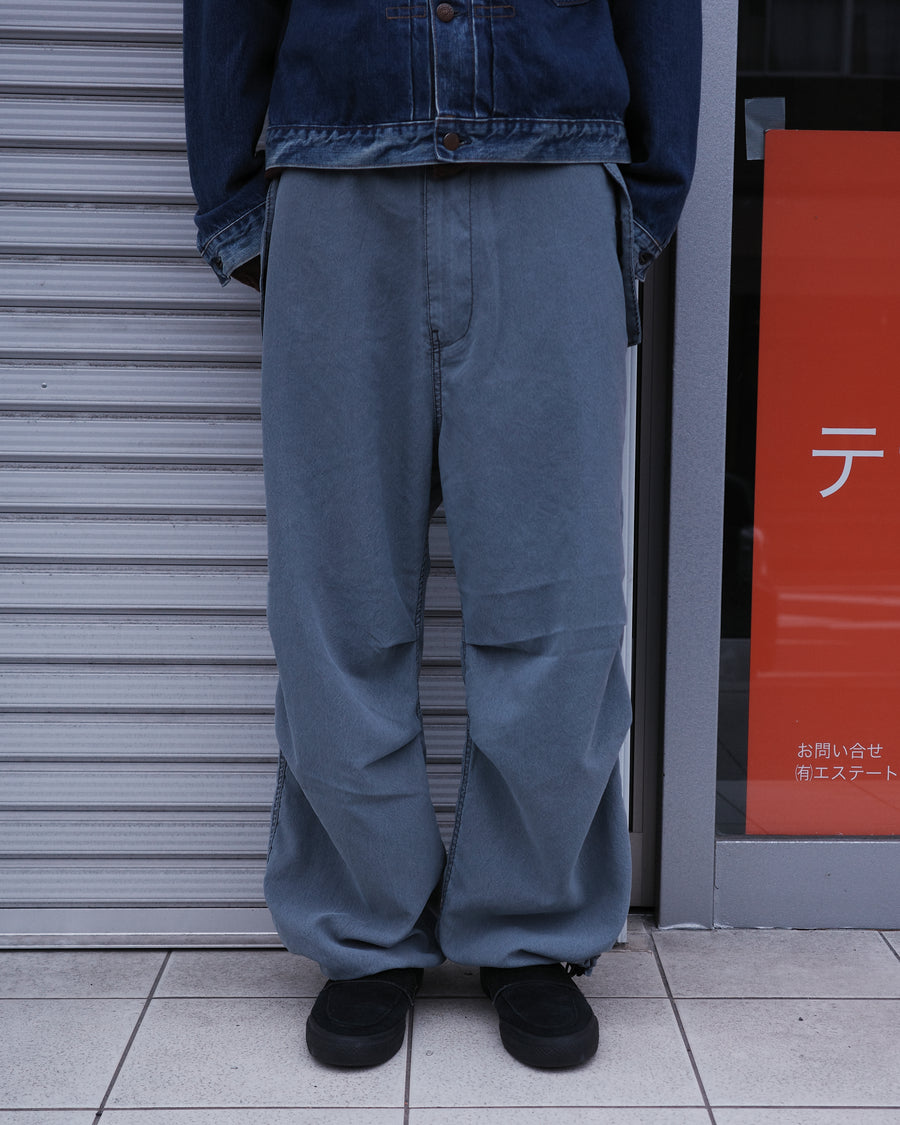 ポリエステル100％ながら、綿のような質感と軽量性を備えた高機能素材を採用。タスラン加工糸によるポリエステルオックスは、シワになりにくく速乾性にも優れています。染色が困難なポリエステルに特殊顔料染めを施すことで、化繊特有の光沢を抑え、ナチュラルで奥行きのある絶妙なフェード感と落ち着いた表情を実現しました。

High-performance polyester oxford with a cotton-like touch, offering quick-dry and wrinkle-resistant benefits. This GRAY BLUE item features a special pigment dye—a rare process for polyester—achieving a sophisticated, faded texture and a matte finish that perfectly balances technical utility with a natural, lived-in aesthetic.