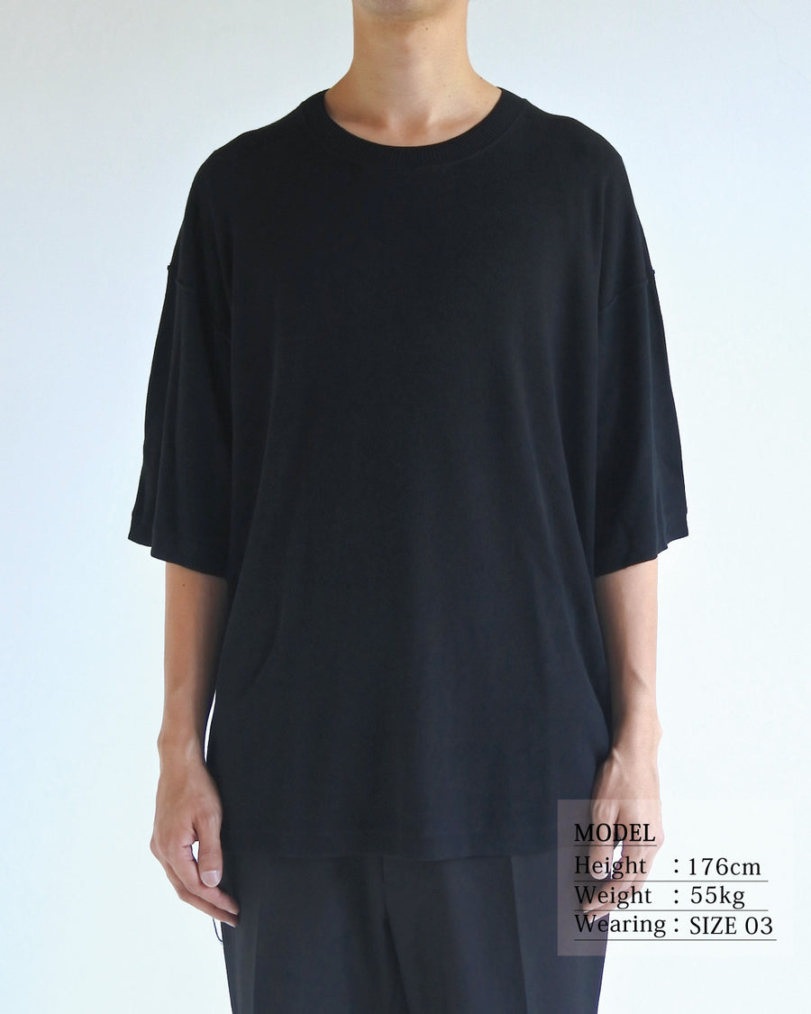 ディテールを極限まで削ぎ落とし、着心地とシルエットを追求したニットTシャツ。気候変化に対応する新たなアプローチとして、軽量で吸水・放湿性に優れた竹（バンブー）素材を採用しました。滑らかでとろみのある肌触りと、袖を通した瞬間に感じる清涼感は格別です。家庭洗濯も可能で、日常に圧倒的な心地よさを提供します。

A minimalist knit T-shirt focused entirely on fit and comfort. Crafted from bamboo yarn, this lightweight, durable material offers exceptional moisture absorption and a refreshing cool-to-the-touch feel. This BLACK piece features a silky, fluid drape that provides overwhelming comfort, perfect for changing climates, and is conveniently home-washable.