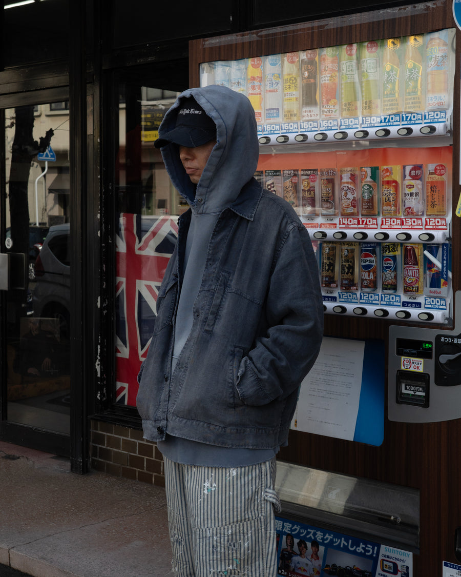 利便性の高い多機能ポケットを備えた、フレンチリネンのユーティリティジャケット。肉厚ながら「とろみ」のある柔らかなフレンチリネンを採用し、清涼感のある着心地を実現しました。硫化染め後に水を使用しないサスティナブルブリーチ加工を施すことで、環境に配慮しながらも、長年着込んだような深みのある色褪せとヴィンテージライクな佇まいを表現しています。

A utility jacket featuring functional pockets and a relaxed silhouette. Crafted from thick yet supple French Linen for a cool, soft touch. This NAVY piece undergoes a sulfur-dye and waterless sustainable bleach process, authentically recreating a deep, sun-faded vintage character while staying eco-conscious.