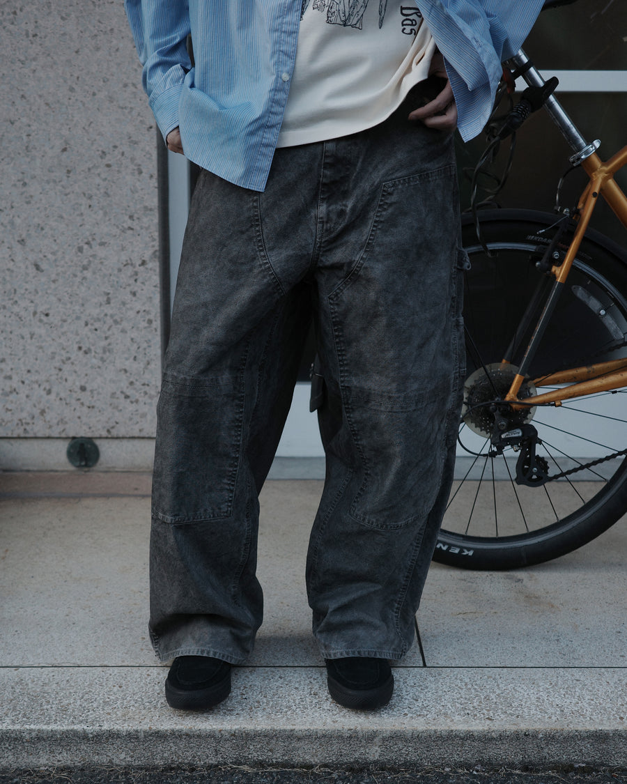通年着用できるスタンダードなペインターパンツ。ややワイドで長めに設定したレングスは、ミリ単位の調整により絶妙なバランスに仕上げました。素材には強度と耐久性に優れた8号帆布を採用。特殊顔料染めを施すことで、ムラ感のある独自の奥行きと、穿き込むほどにアタリが増す豊かな経年変化を楽しめる一本です。

Standard painter pants designed for year-round wear. The slightly wide, long-length silhouette has been carefully refined for a perfect balance. Crafted from durable No.8 canvas, this BLACK pair features a special pigment dye that creates a unique, mottled depth. The rugged fabric is built to develop a beautiful patina and character over time.