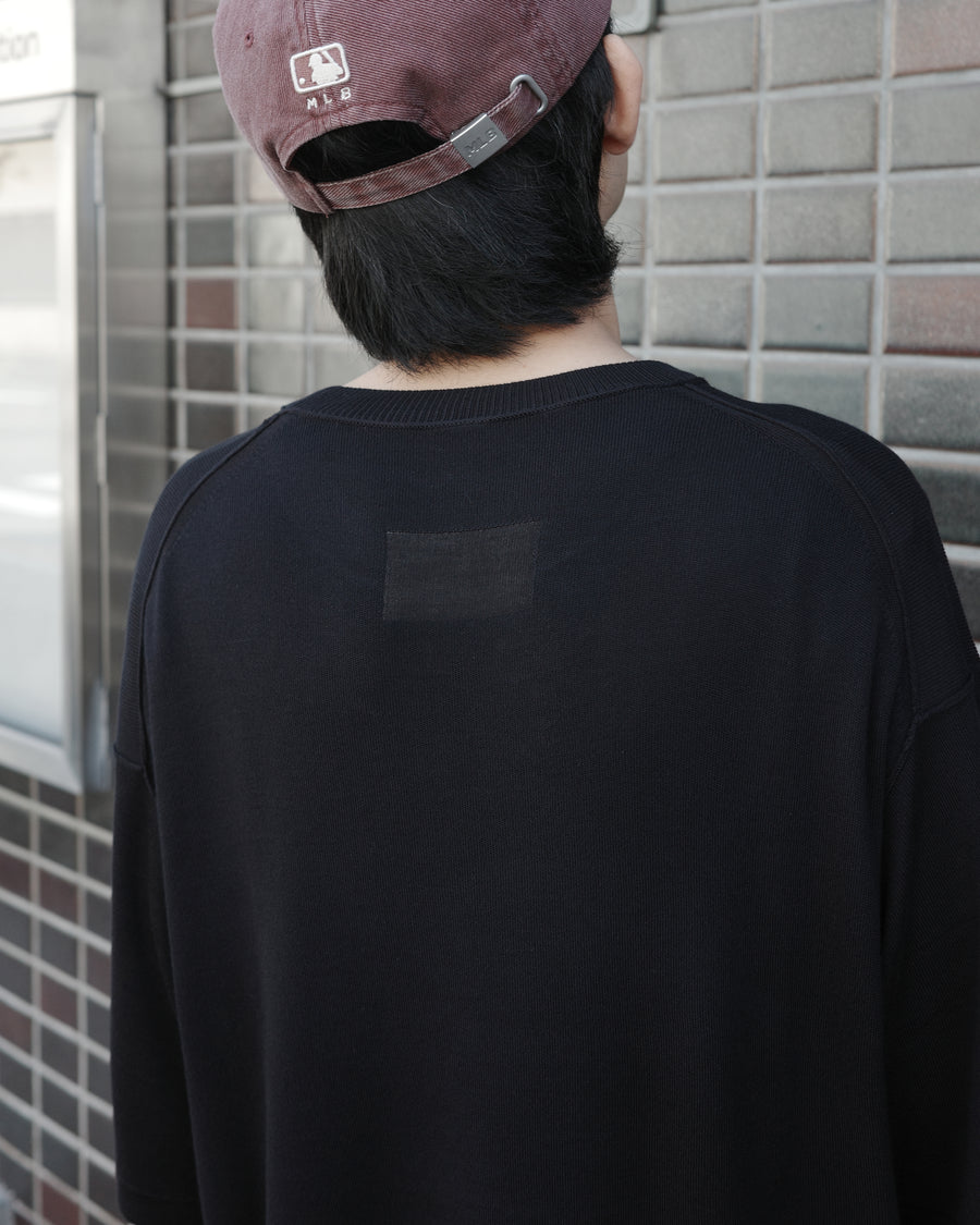 ディテールを極限まで削ぎ落とし、着心地とシルエットを追求したニットTシャツ。気候変化に対応する新たなアプローチとして、軽量で吸水・放湿性に優れた竹（バンブー）素材を採用しました。滑らかでとろみのある肌触りと、袖を通した瞬間に感じる清涼感は格別です。家庭洗濯も可能で、日常に圧倒的な心地よさを提供します。

A minimalist knit T-shirt focused entirely on fit and comfort. Crafted from bamboo yarn, this lightweight, durable material offers exceptional moisture absorption and a refreshing cool-to-the-touch feel. This BLACK piece features a silky, fluid drape that provides overwhelming comfort, perfect for changing climates, and is conveniently home-washable.