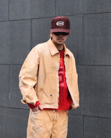 【 商品名：リメイクデトロイトダックジャケット 】

本製品は、ゆとりのある身幅とややクロップド丈に設計されたイエローカラーのジャケットで、インナーアイテムとのレイヤードを楽しめるバランスの良いシルエットが特徴です。生地には頒布の中でも最も薄手の11号帆布生地を使用しており、強度・耐久性に優れるとともに、着用を重ねるごとにアタリなどの経年変化を味わえる素材です。さらに、水や薬品の使用量を抑えながら生地の凹凸部分のアタリを強調し、同時に自然な脱色感を生み出す特殊エイジング加工を施し、加えてサンフェードによるダメージ加工も行うことで、より深みのある表情に仕上げています。