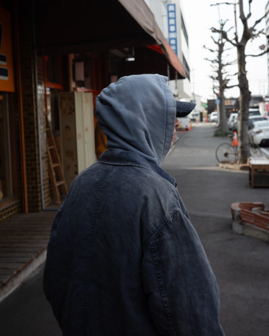 利便性の高い多機能ポケットを備えた、フレンチリネンのユーティリティジャケット。肉厚ながら「とろみ」のある柔らかなフレンチリネンを採用し、清涼感のある着心地を実現しました。硫化染め後に水を使用しないサスティナブルブリーチ加工を施すことで、環境に配慮しながらも、長年着込んだような深みのある色褪せとヴィンテージライクな佇まいを表現しています。

A utility jacket featuring functional pockets and a relaxed silhouette. Crafted from thick yet supple French Linen for a cool, soft touch. This NAVY piece undergoes a sulfur-dye and waterless sustainable bleach process, authentically recreating a deep, sun-faded vintage character while staying eco-conscious.