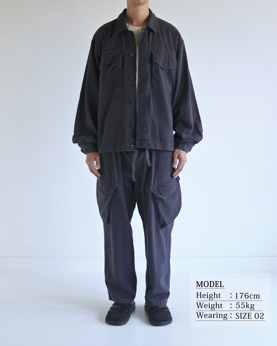 ミリタリーのシャツジャケットを現代的シルエットに更新。裾のドローコードで着丈のニュアンスを自在に調整可能です。素材には、やや甘織りで肌馴染みの良い10sヘリンボンを採用。ストーンバイオウォッシュを施すことで、クラシカルな生地感に柔らかな風合いとこなれ感をプラスした、着回し力の高い一着に仕上げました。

A modern update to the classic military shirt jacket, featuring hem drawcords for an adjustable silhouette. Crafted from 10s herringbone, slightly loose-knitted for a soft, comfortable touch. This CHARCOAL piece has been treated with a stone bio-wash, giving the traditional weave a natural, worn-in texture and a sophisticated casual feel.