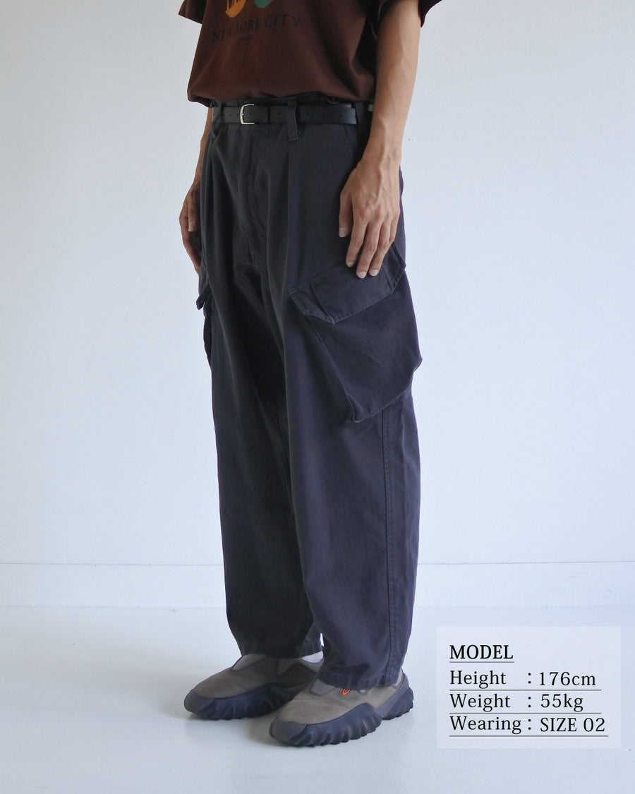 ミリタリートラウザーズをベースに、シルエットを現代的にリファイン。印象的な斜めのカーゴポケットが、立体感と実用性を両立させています。裾にかけて緩やかに絞られたテーパードラインにより、無骨ながらも洗練された印象に。素材には肌馴染みの良い10sヘリンボンを採用し、ストーンバイオウォッシュで柔らかな風合いとこなれ感を引き出しました。

Military trousers refined with a modern tapered silhouette. The distinctive slanted cargo pockets offer both practical utility and a structured look. Crafted from soft, classic 10s herringbone, this CHARCOAL pair has been treated with a stone bio-wash, providing a comfortable, worn-in texture and a sophisticated take on rugged style.