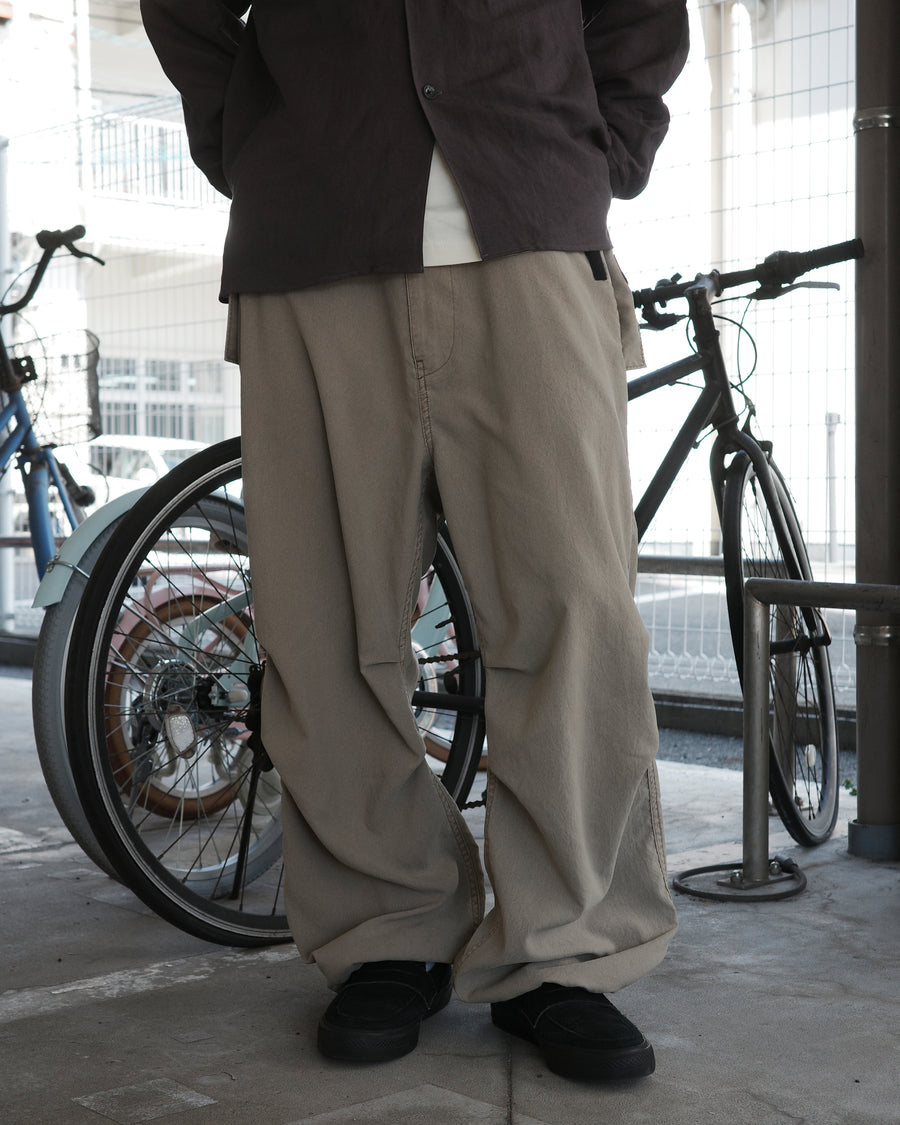 ポリエステル100％ながら、綿のような質感と軽量性を備えた高機能素材を採用。タスラン加工糸によるポリエステルオックスは、シワになりにくく速乾性にも優れています。染色が困難なポリエステルに特殊顔料染めを施すことで、化繊特有の光沢を抑え、ナチュラルで奥行きのある絶妙なフェード感と落ち着いた表情を実現しました。

High-performance polyester oxford with a cotton-like touch, offering quick-dry and wrinkle-resistant benefits. This GRAY BEIGE item features a special pigment dye—a rare process for polyester—achieving a sophisticated, faded texture and a matte finish that perfectly balances technical utility with a natural, lived-in aesthetic.