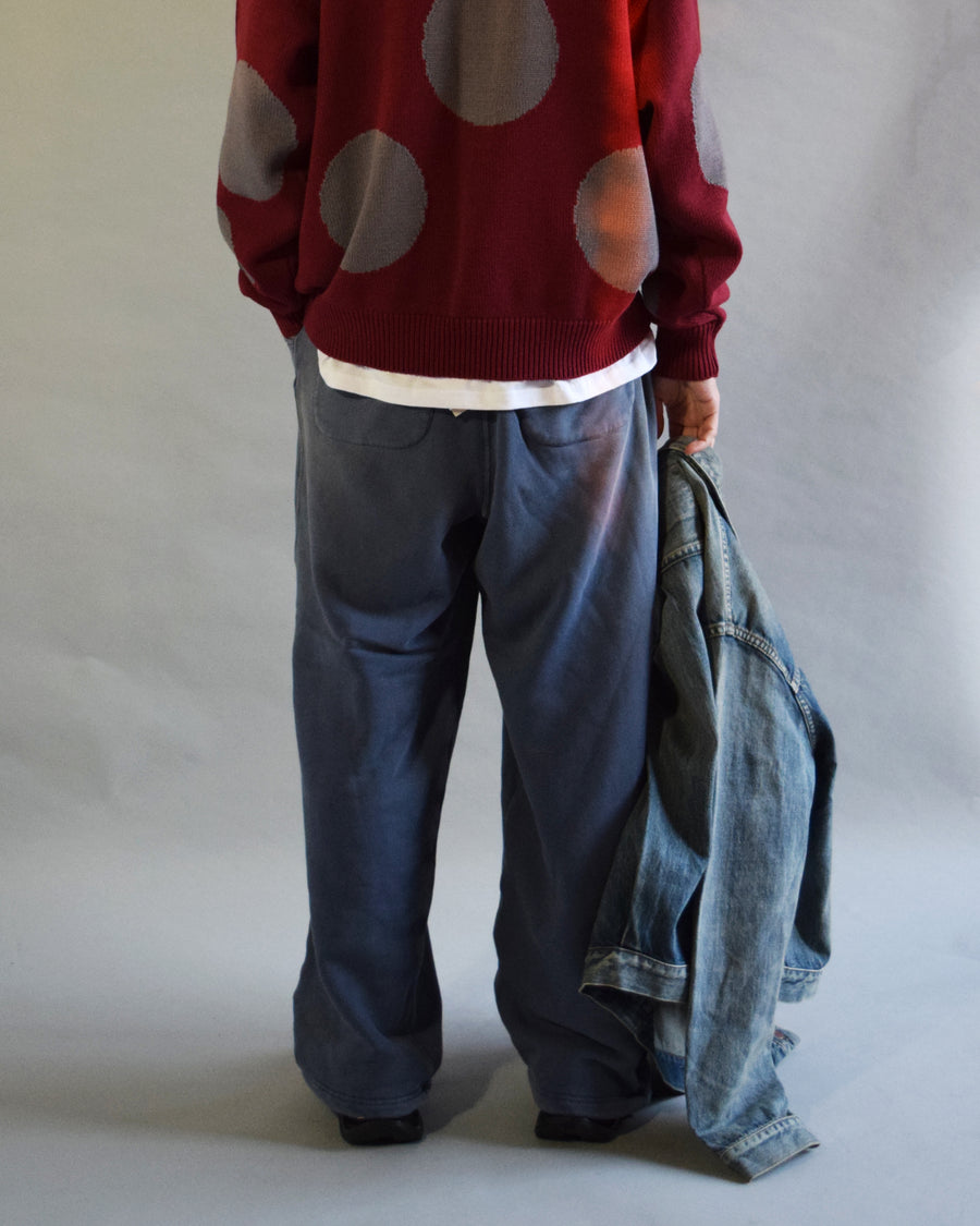 フロントにタックを施し、腰まわりにゆとりをもたせたスウェットパンツ。低速で丁寧に編み立てた30/10裏毛を使用し、ドライな質感と程よいハリ・コシを実現しました。硫化染め後、水を使用しないサスティナブルブリーチとダメージ加工を施すことで、環境に配慮しながら、長年の着用と日焼けによるヴィンテージの風合いをリアルに表現しています。
Sweatpants featuring front tucks for a relaxed waist silhouette. Crafted from 30/10 French Terry for a dry, structured touch, this BLUE pair undergoes a waterless sustainable bleach and damage process. It authentically recreates the sun-faded look of a vintage favorite while minimizing environmental impact.