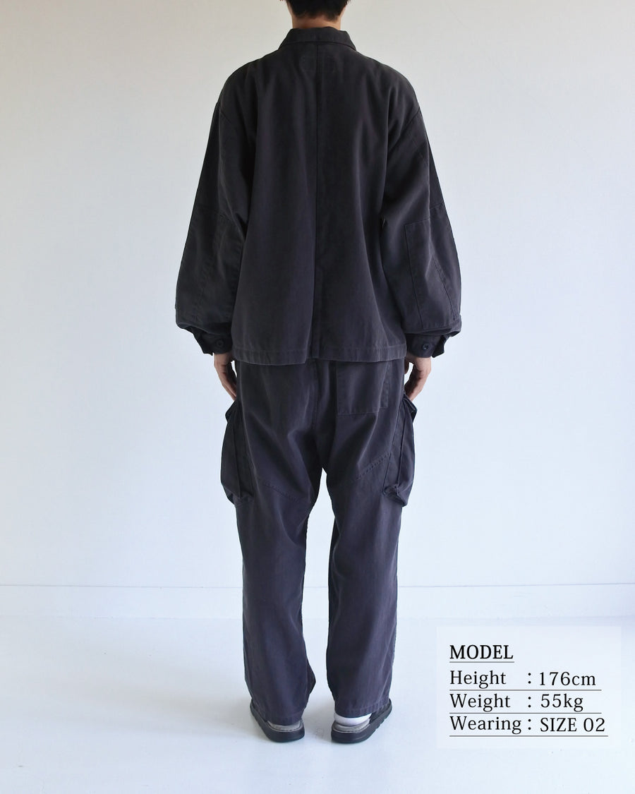 ミリタリーのシャツジャケットを現代的シルエットに更新。裾のドローコードで着丈のニュアンスを自在に調整可能です。素材には、やや甘織りで肌馴染みの良い10sヘリンボンを採用。ストーンバイオウォッシュを施すことで、クラシカルな生地感に柔らかな風合いとこなれ感をプラスした、着回し力の高い一着に仕上げました。

A modern update to the classic military shirt jacket, featuring hem drawcords for an adjustable silhouette. Crafted from 10s herringbone, slightly loose-knitted for a soft, comfortable touch. This CHARCOAL piece has been treated with a stone bio-wash, giving the traditional weave a natural, worn-in texture and a sophisticated casual feel.