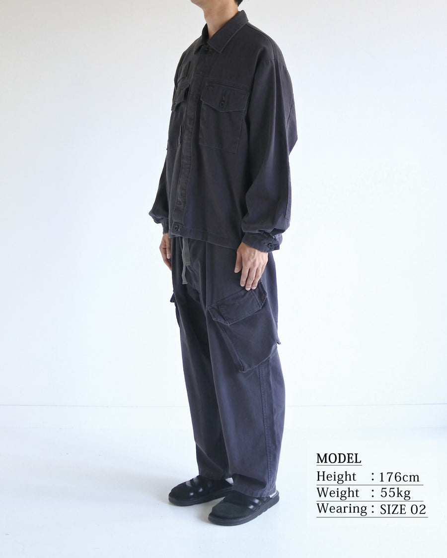 ミリタリーのシャツジャケットを現代的シルエットに更新。裾のドローコードで着丈のニュアンスを自在に調整可能です。素材には、やや甘織りで肌馴染みの良い10sヘリンボンを採用。ストーンバイオウォッシュを施すことで、クラシカルな生地感に柔らかな風合いとこなれ感をプラスした、着回し力の高い一着に仕上げました。

A modern update to the classic military shirt jacket, featuring hem drawcords for an adjustable silhouette. Crafted from 10s herringbone, slightly loose-knitted for a soft, comfortable touch. This CHARCOAL piece has been treated with a stone bio-wash, giving the traditional weave a natural, worn-in texture and a sophisticated casual feel.