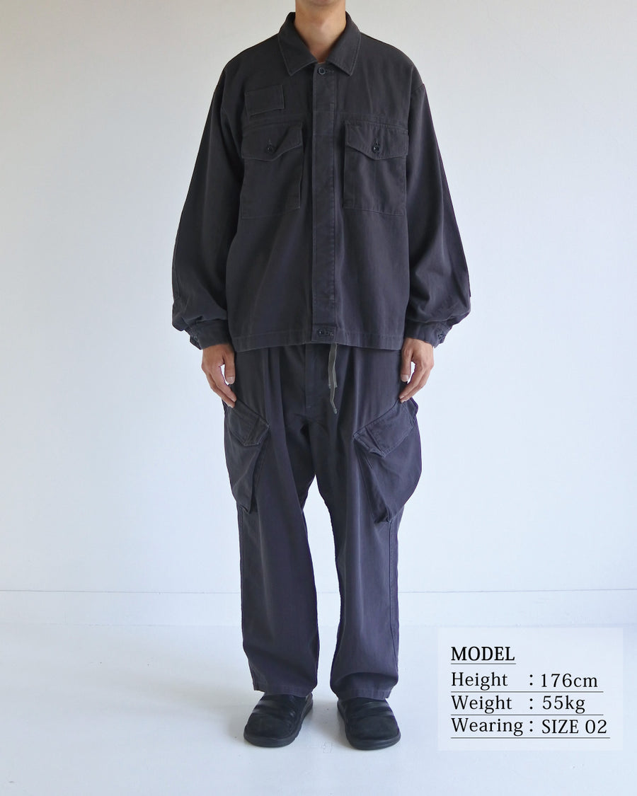 ミリタリーのシャツジャケットを現代的シルエットに更新。裾のドローコードで着丈のニュアンスを自在に調整可能です。素材には、やや甘織りで肌馴染みの良い10sヘリンボンを採用。ストーンバイオウォッシュを施すことで、クラシカルな生地感に柔らかな風合いとこなれ感をプラスした、着回し力の高い一着に仕上げました。

A modern update to the classic military shirt jacket, featuring hem drawcords for an adjustable silhouette. Crafted from 10s herringbone, slightly loose-knitted for a soft, comfortable touch. This CHARCOAL piece has been treated with a stone bio-wash, giving the traditional weave a natural, worn-in texture and a sophisticated casual feel.