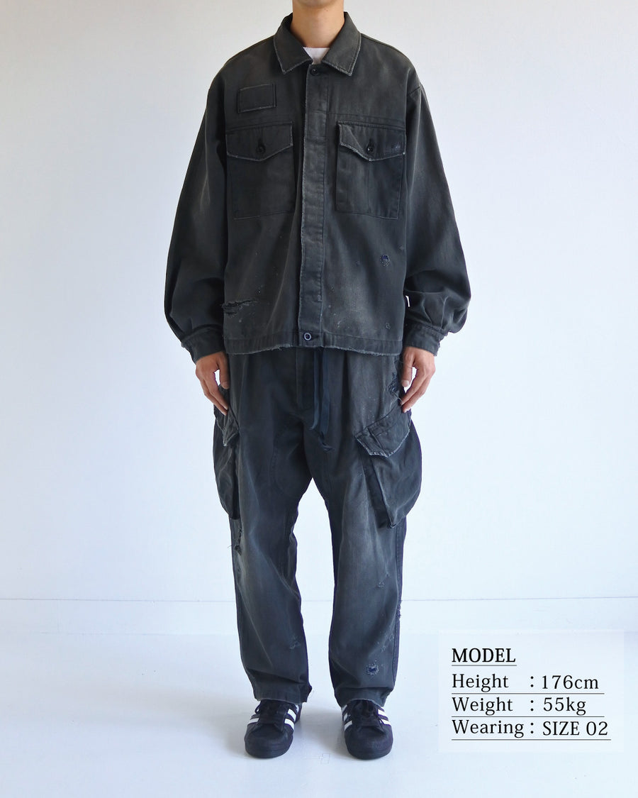ミリタリーのシャツジャケットを現代的シルエットに更新。裾のドローコードでスタイルに合わせた変化を楽しめます。素材には肌馴染みの良い10sヘリンボンを採用。環境に配慮した特殊エイジング・サンフェード加工とダメージ加工を施すことで、クラシカルな生地にリアリティのある褪色感とヴィンテージライクな佇まいを表現しました。

A modern military shirt jacket with hem drawcords for an adjustable silhouette. Crafted from soft 10s herringbone, this BLACK piece undergoes a special sun-fade and damage process. It achieves a realistic, time-worn vintage look with authentic distressing while minimizing environmental impact through eco-conscious processing.
