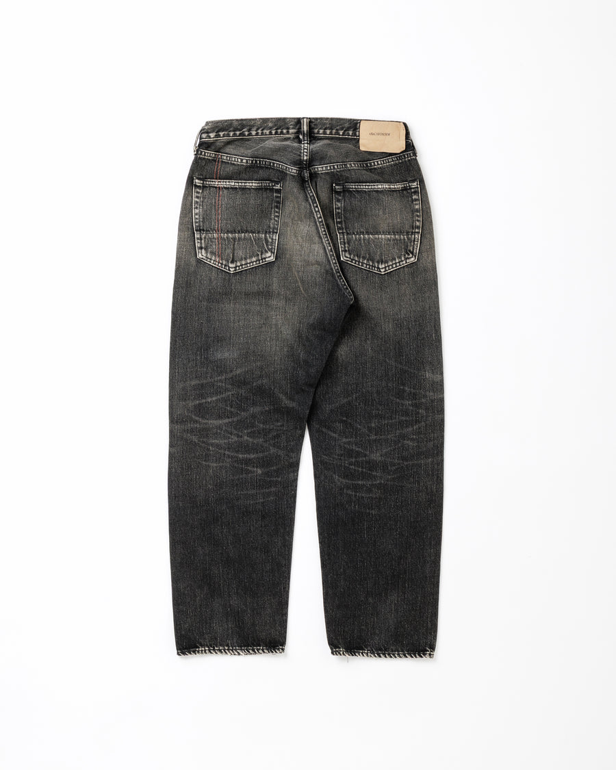 ANACHRONORM定番のレギュラーテーパード5Pパンツをベースに、リメイクで再構築した一本。
腰回りにはゆとりを持たせつつ、裾へ向かってすっきりと収まる美しいテーパードシルエットが特徴です。
タテ糸は硫化ロープ染色を施した芯白仕様で、ブラックからグレーへ自然にフェードする豊かな経年変化が魅力。
ムラ糸が生み出す自然な陰影により、ヴィンテージライクな表情を楽しめます。
さらにタテヨコに硫化ブラックのスラブ糸を使用し、ベーストーンを抑えながらもアタリを際立たせた奥行きのあるコントラストを表現。
リアルなユーズド感を備えた、加工映えする一本に仕上げています。
A reconstructed take on ANACHRONORM’s classic Regular Tapered 5P Pants, refined through its remake design.
The fit offers room around the waist with a clean taper toward the hem, ensuring both comfort and sharp lines.
Warp yarns a