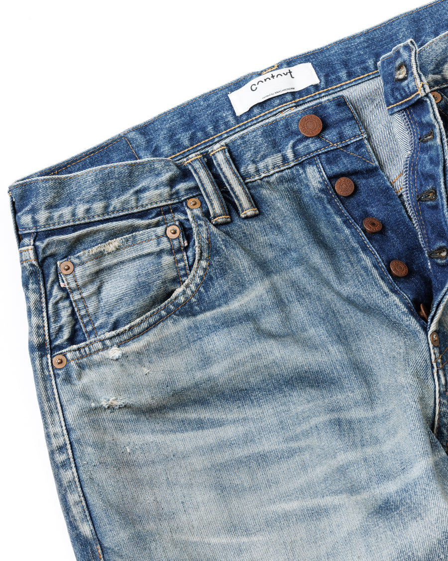 1985年のLEVIS 550をベースに再構築した、ワイドテーパードのリメイク5Pデニム。
12.5ozデニムのタテ糸には中白のインディゴロープ染色糸を使用し、ムラ感のある豊かな表情を演出。タテ落ちとインディゴの濃淡を活かすことで、ヴィンテージにはない独自の風合いを表現しています。さらに手作業のトーンコントロールと特別なエイジング加工を加えることで奥行きある仕上がりに。オリジナル染料の吹き付けにより、モダンでソリッドな印象も併せ持つ一本です。This remade 5P denim features a wide tapered silhouette inspired by the 1985 LEVIS 550.
The 12.5oz denim uses medium-white indigo rope–dyed warp yarns, giving it a textured, slubby character.
By highlighting vertical fading and vivid indigo variations, it achieves a look distinct from vin