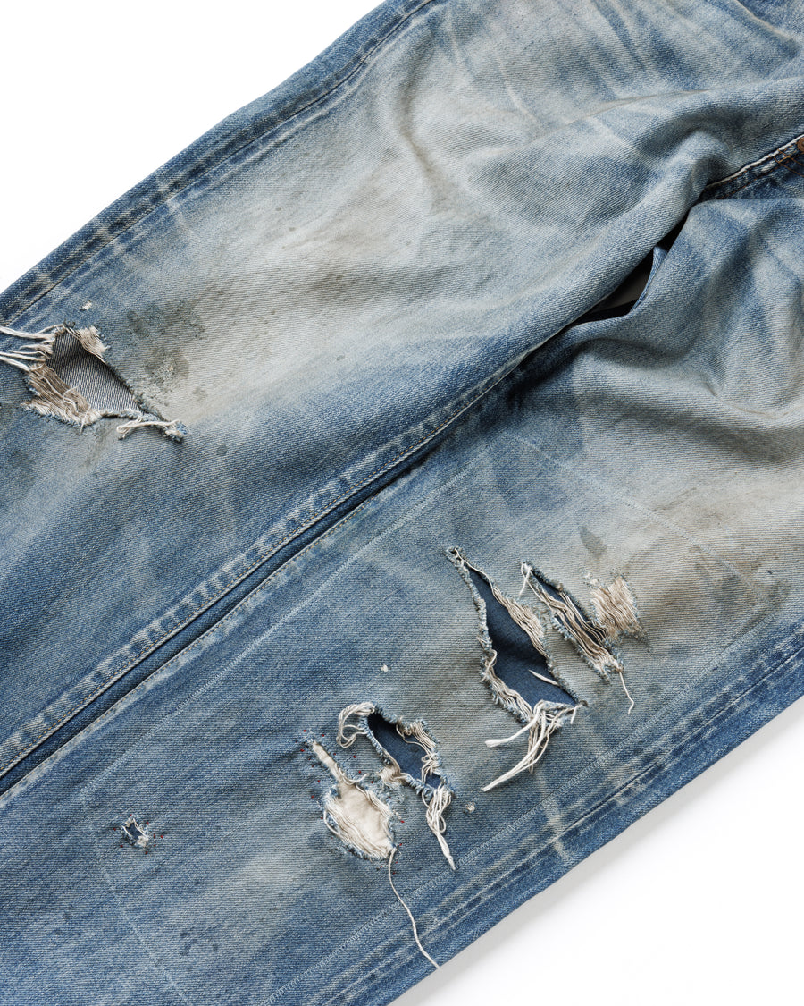 1985年のLEVIS 550をベースに再構築した、ワイドテーパードのリメイク5Pデニム。
12.5ozデニムのタテ糸には中白のインディゴロープ染色糸を使用し、ムラ感のある豊かな表情を演出。タテ落ちとインディゴの濃淡を活かすことで、ヴィンテージにはない独自の風合いを表現しています。さらに手作業のトーンコントロールと特別なエイジング加工を加えることで奥行きある仕上がりに。オリジナル染料の吹き付けにより、モダンでソリッドな印象も併せ持つ一本です。This remade 5P denim features a wide tapered silhouette inspired by the 1985 LEVIS 550.
The 12.5oz denim uses medium-white indigo rope–dyed warp yarns, giving it a textured, slubby character.
By highlighting vertical fading and vivid indigo variations, it achieves a look distinct from vin