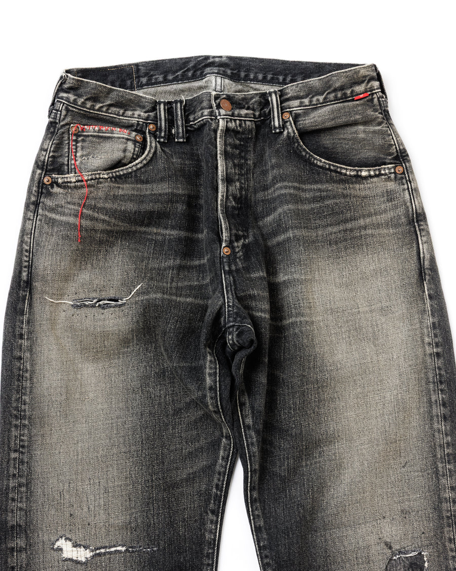 ANACHRONORM定番のレギュラーテーパード5Pパンツをベースに、リメイクで再構築した一本。
腰回りにはゆとりを持たせつつ、裾へ向かってすっきりと収まる美しいテーパードシルエットが特徴です。
タテ糸は硫化ロープ染色を施した芯白仕様で、ブラックからグレーへ自然にフェードする豊かな経年変化が魅力。
ムラ糸が生み出す自然な陰影により、ヴィンテージライクな表情を楽しめます。
さらにタテヨコに硫化ブラックのスラブ糸を使用し、ベーストーンを抑えながらもアタリを際立たせた奥行きのあるコントラストを表現。
リアルなユーズド感を備えた、加工映えする一本に仕上げています。
A reconstructed take on ANACHRONORM’s classic Regular Tapered 5P Pants, refined through its remake design.
The fit offers room around the waist with a clean taper toward the hem, ensuring both comfort and sharp lines.
Warp yarns a