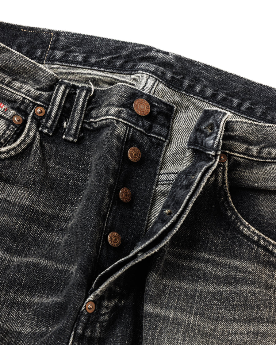 ANACHRONORM定番のレギュラーテーパード5Pパンツをベースに、リメイクで再構築した一本。
腰回りにはゆとりを持たせつつ、裾へ向かってすっきりと収まる美しいテーパードシルエットが特徴です。
タテ糸は硫化ロープ染色を施した芯白仕様で、ブラックからグレーへ自然にフェードする豊かな経年変化が魅力。
ムラ糸が生み出す自然な陰影により、ヴィンテージライクな表情を楽しめます。
さらにタテヨコに硫化ブラックのスラブ糸を使用し、ベーストーンを抑えながらもアタリを際立たせた奥行きのあるコントラストを表現。
リアルなユーズド感を備えた、加工映えする一本に仕上げています。
A reconstructed take on ANACHRONORM’s classic Regular Tapered 5P Pants, refined through its remake design.
The fit offers room around the waist with a clean taper toward the hem, ensuring both comfort and sharp lines.
Warp yarns a