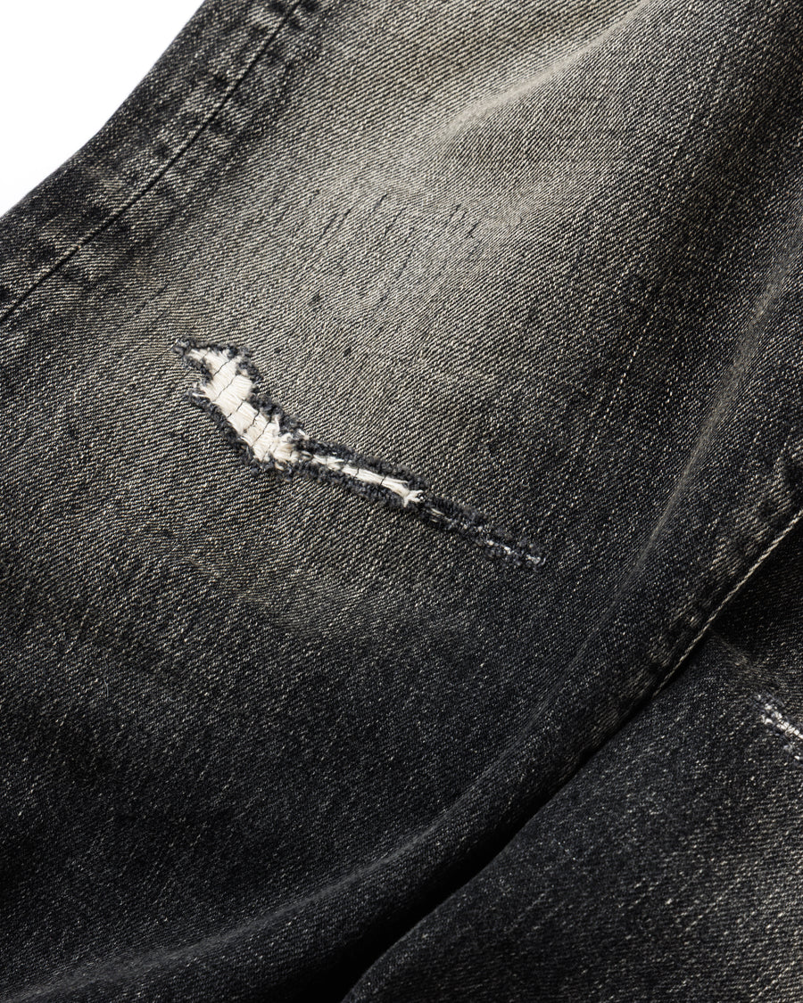 ANACHRONORM定番のレギュラーテーパード5Pパンツをベースに、リメイクで再構築した一本。
腰回りにはゆとりを持たせつつ、裾へ向かってすっきりと収まる美しいテーパードシルエットが特徴です。
タテ糸は硫化ロープ染色を施した芯白仕様で、ブラックからグレーへ自然にフェードする豊かな経年変化が魅力。
ムラ糸が生み出す自然な陰影により、ヴィンテージライクな表情を楽しめます。
さらにタテヨコに硫化ブラックのスラブ糸を使用し、ベーストーンを抑えながらもアタリを際立たせた奥行きのあるコントラストを表現。
リアルなユーズド感を備えた、加工映えする一本に仕上げています。
A reconstructed take on ANACHRONORM’s classic Regular Tapered 5P Pants, refined through its remake design.
The fit offers room around the waist with a clean taper toward the hem, ensuring both comfort and sharp lines.
Warp yarns a