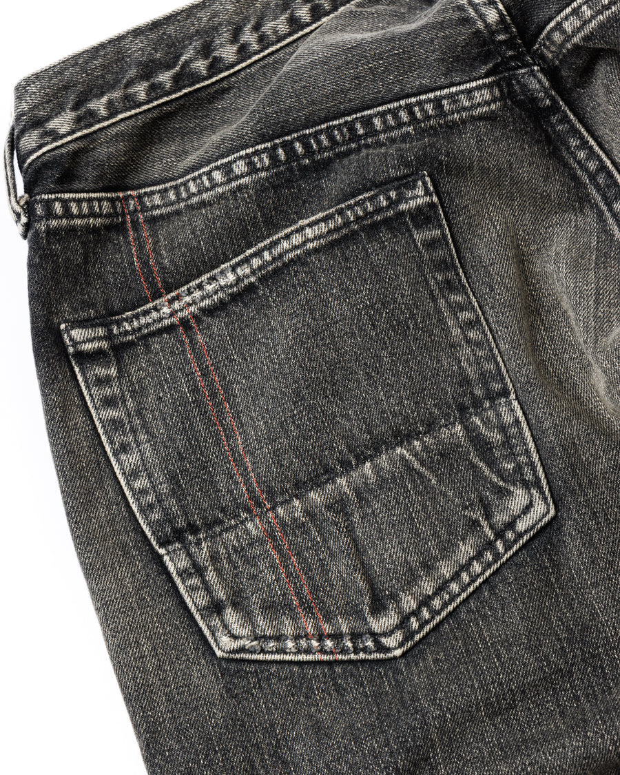 ANACHRONORM定番のレギュラーテーパード5Pパンツをベースに、リメイクで再構築した一本。
腰回りにはゆとりを持たせつつ、裾へ向かってすっきりと収まる美しいテーパードシルエットが特徴です。
タテ糸は硫化ロープ染色を施した芯白仕様で、ブラックからグレーへ自然にフェードする豊かな経年変化が魅力。
ムラ糸が生み出す自然な陰影により、ヴィンテージライクな表情を楽しめます。
さらにタテヨコに硫化ブラックのスラブ糸を使用し、ベーストーンを抑えながらもアタリを際立たせた奥行きのあるコントラストを表現。
リアルなユーズド感を備えた、加工映えする一本に仕上げています。
A reconstructed take on ANACHRONORM’s classic Regular Tapered 5P Pants, refined through its remake design.
The fit offers room around the waist with a clean taper toward the hem, ensuring both comfort and sharp lines.
Warp yarns a