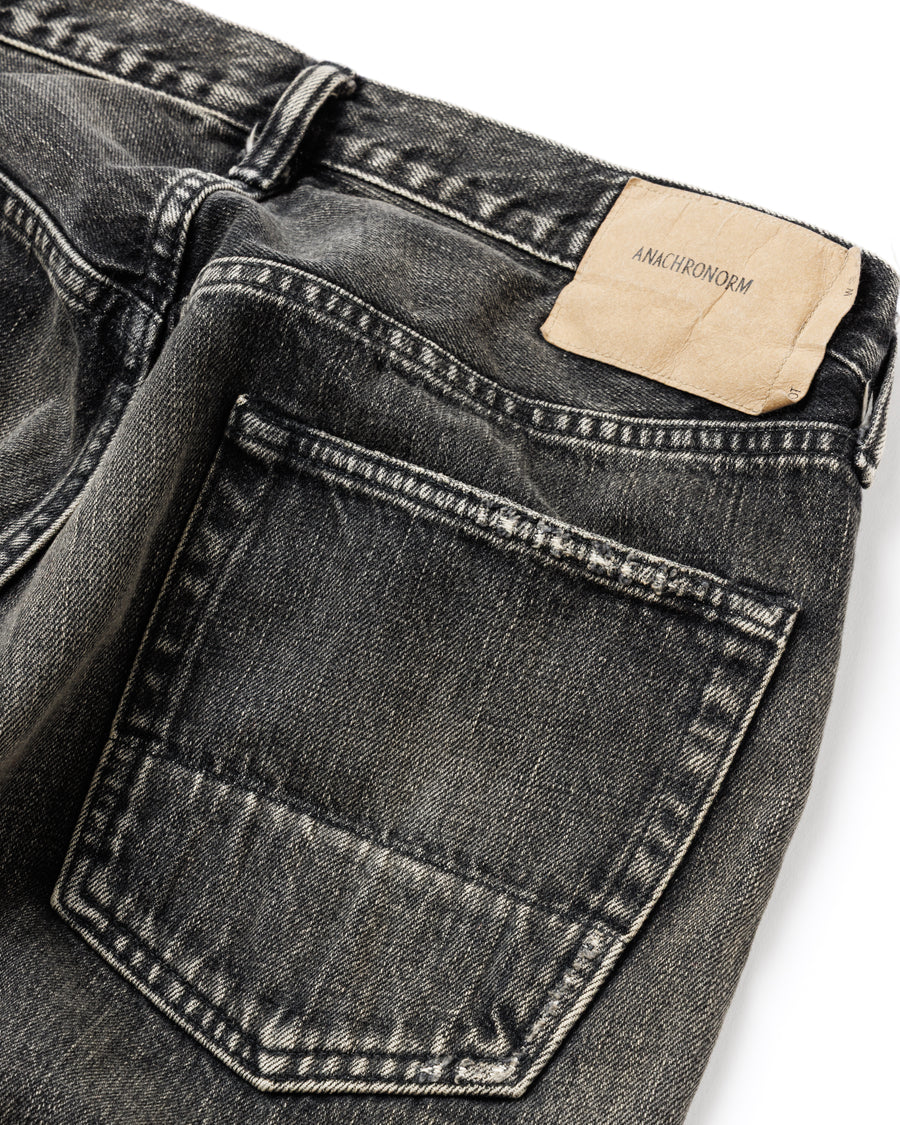 ANACHRONORM定番のレギュラーテーパード5Pパンツをベースに、リメイクで再構築した一本。
腰回りにはゆとりを持たせつつ、裾へ向かってすっきりと収まる美しいテーパードシルエットが特徴です。
タテ糸は硫化ロープ染色を施した芯白仕様で、ブラックからグレーへ自然にフェードする豊かな経年変化が魅力。
ムラ糸が生み出す自然な陰影により、ヴィンテージライクな表情を楽しめます。
さらにタテヨコに硫化ブラックのスラブ糸を使用し、ベーストーンを抑えながらもアタリを際立たせた奥行きのあるコントラストを表現。
リアルなユーズド感を備えた、加工映えする一本に仕上げています。
A reconstructed take on ANACHRONORM’s classic Regular Tapered 5P Pants, refined through its remake design.
The fit offers room around the waist with a clean taper toward the hem, ensuring both comfort and sharp lines.
Warp yarns a