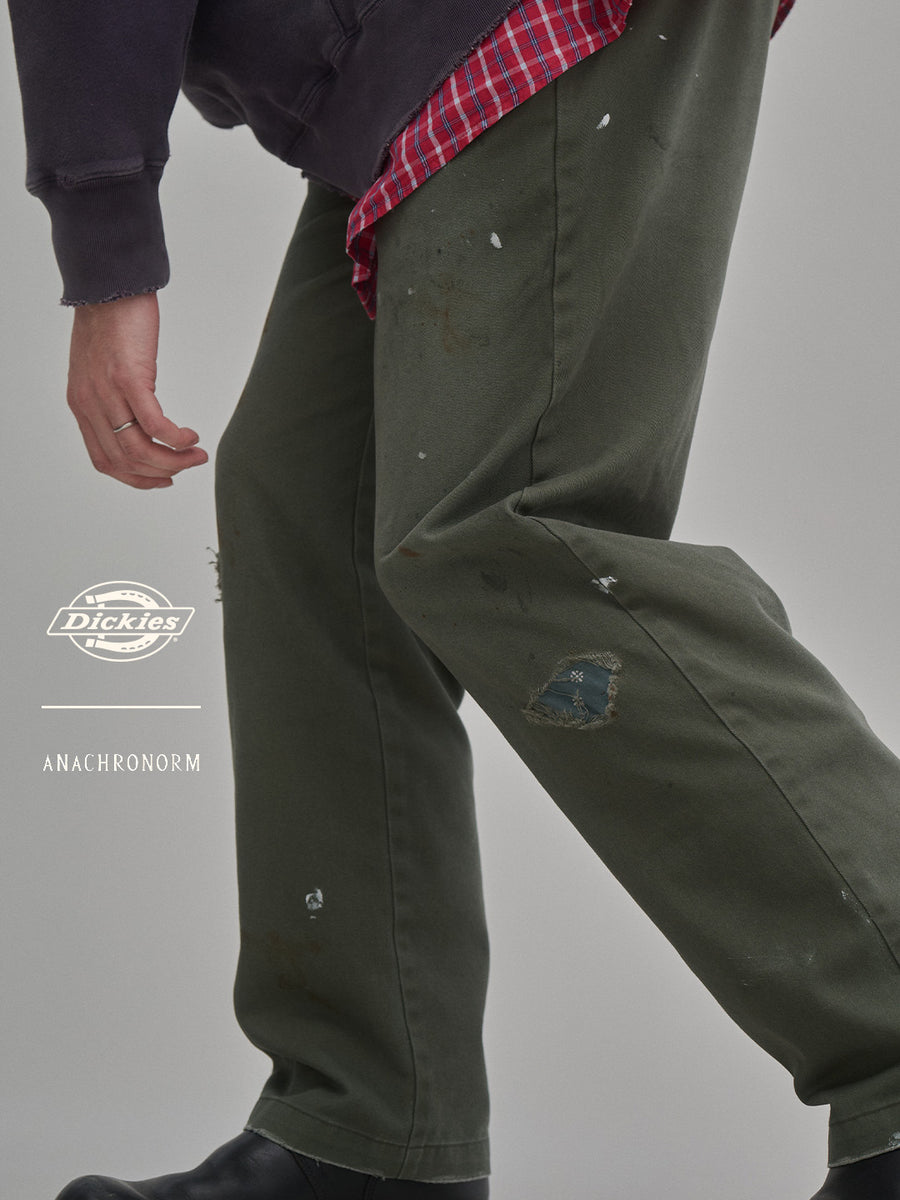 Dickiesのアイコンであるオリジナルワークパンツをベースに、ANACHRONORMがリアルなエイジングとリペア加工を施しました。
8.5ozのTCツイル生地はハリがあり丈夫で、シワになりにくく汚れにも強い素材。
タフなTC素材に5工程の加工を施し、長年履き込んだような風合いを再現しています。
膝には異なる生地の当て布を使用し、破れを補修したようなリペア風リメイクに仕上げました。
Based on the iconic Dickies Original Work Pants, reimagined with ANACHRONORM’s signature aging and repair aesthetic.
Made from sturdy 8.5oz TC twill, known for its durability and resistance to wrinkles and stains.
A five-step processing method recreates the look of years of wear on the tough TC fabric.