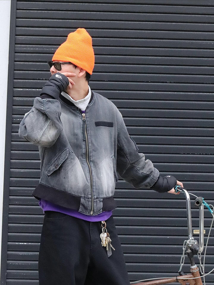 【 商品名：エイジングデュアルデニムMA-1 】

本製品は、ブランドのメイン素材であるデニムを使用し、ディティールを忠実に再現しながらシルエットを整えたブラックカラーのMA-1ジャケットです。中綿は入っていませんが、ライトオンスデニムを採用し、二重縫製によって柔らかく程よい肉感のある着心地に仕上げています。生地にはムラ糸を使用した8ozデニムを採用しており、シャープなムラ形状と粗野な風合いがより一層ヴィンテージ感を引き立てます。さらに加工には、全体にリアルなアタリ感を与えるエイジング加工を施し、深みのある表情を持たせています。