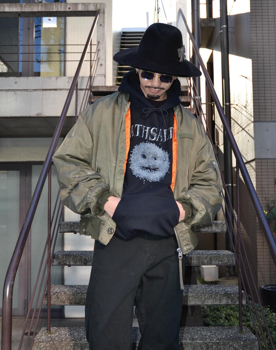 忠実なディテールを保ちながら、シルエットを現代的に整えたMA-1ジャケット。加工によりヴィンテージの風合いを再現した一着です。肉厚でミリタリーらしいツイル生地を使用し、打ち込みの密度や肌触りまでビンテージMA-1に近い仕上がりに。さらに、ダートペイントや特殊吹き付け、ダメージ加工を重ね、洗いをかけて染料を自然に剥がすことで、深みのある表情を生み出しています。カラーはオリーブ。