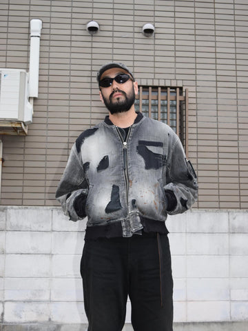 ブランドを象徴するデニムで構築した、MA-1ベースのリメイクジャケット。ライトオンスデニムを二重縫製することで、柔らかさと程よい肉感を実現しています。8ozムラ糸デニムがもつ粗野な表情が、強いヴィンテージ感を演出。全体にエイジングを施したうえで、ハードダメージ加工で仕上げた一着。さらに手作業による多様なステッチ補修を重ね、唯一無二の表情に仕上げています。Crafted from the brand’s signature denim, this MA-1–inspired jacket features a refined and faithful silhouette.Lightweight denim with double stitching creates a soft feel and balanced structure.The 8oz slub denim offers a rugged character that enhances its vintage appeal.An overall aging treatment is followed by a hard damage finis
