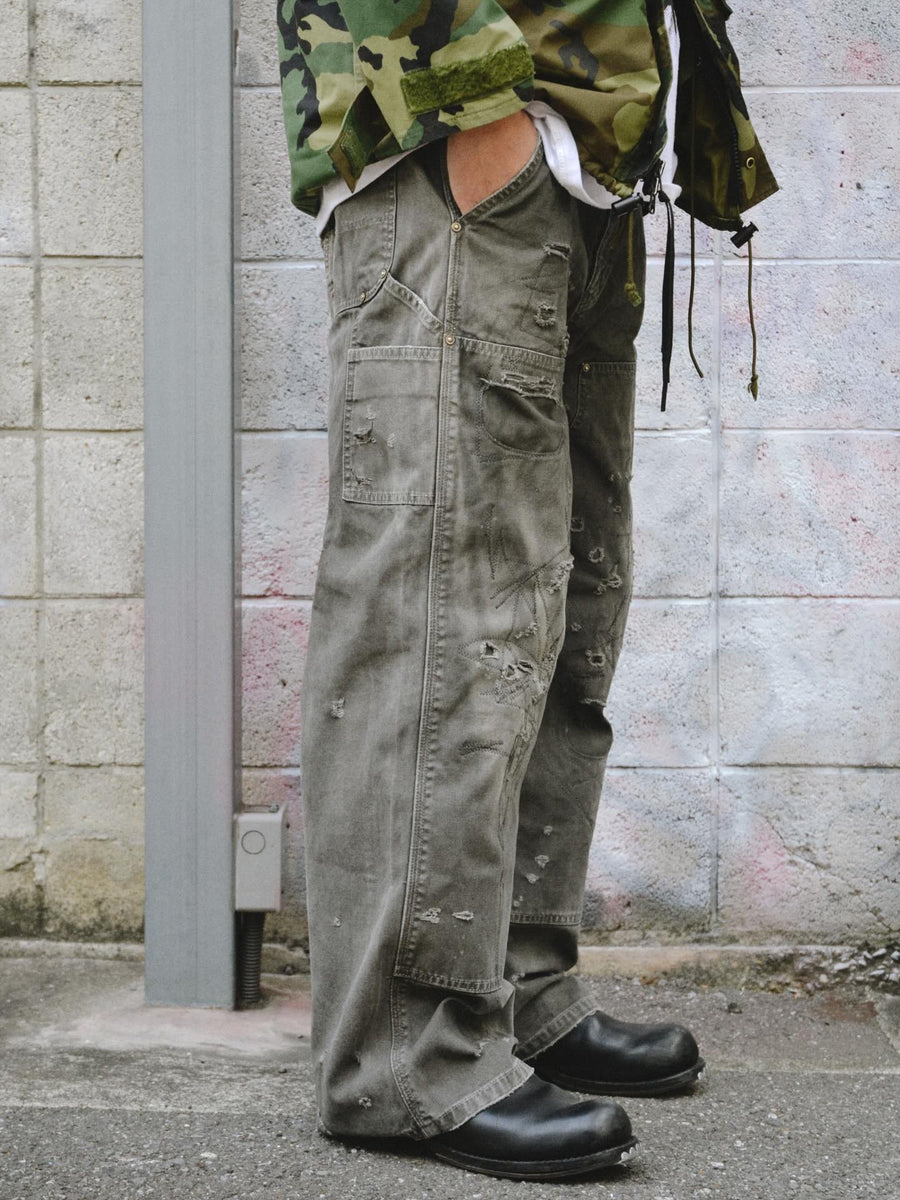 中目黒の「FIFTH GENERAL STORE」とのコラボモデル。同店のダブルニーパンツをベースに、ANACHRONORMが贅沢なリメイクを施しました。高密度ダック地に、独自のG-Brown硫化染めと重層的なバイオ加工、サンフェード、全面の千鳥ステッチ補修を敢行。職人の高度な技術を惜しみなく注ぎ込み、ワークウェアを超越した圧倒的な奥行きとリアリティを追求した究極の一本です。
A collaboration with Nakameguro’s FIFTH GENERAL STORE. Based on their double-knee pants, ANACHRONORM applied luxury distressing, custom G-Brown sulfur dyeing, and meticulous zigzag stitch repairs. It features profound depth and a realistic sun-faded patina, showcasing elite craftsmanship.