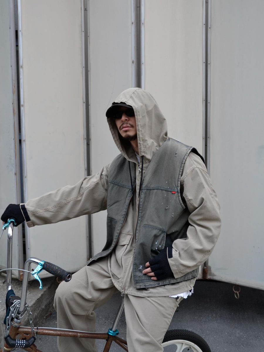 ポリエステル100％でありながら、綿のような質感と軽量性を備えた高機能な一着。タスラン加工糸を使用したポリエステルオックスを採用し、シワになりにくく速乾性に優れたイージーケア性を実現しました。本来染色が困難な素材に特殊顔料染めを施すことで、化繊特有の光沢を抑えた、ナチュラルで奥行きのある絶妙なフェード感を表現しています。

A high-performance piece crafted from polyester oxford, offering a cotton-like touch with lightweight, quick-dry, and wrinkle-resistant properties. This GRAY BEIGE item features a special pigment dye—a rare process for polyester—achieving a sophisticated, faded texture and a matte finish that defies its synthetic origins.