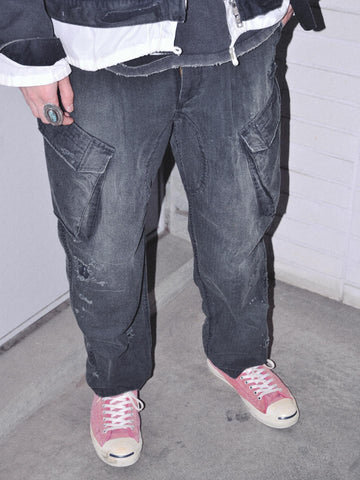 ミリタリートラウザーズを現代的にリファイン。斜めのカーゴポケットが実用的なアクセントを添え、洗練されたテーパードラインが際立ちます。素材には肌馴染みの良い10sヘリンボンを採用。環境に配慮した特殊エイジング・サンフェード加工と随所のリメイクにより、リアリティのある褪色感とヴィンテージな佇まいを表現しました。

Modernized military trousers with a refined tapered fit and slanted cargo pockets. Crafted from soft 10s herringbone, this BLACKA pair features special sun-fading and remake details. It achieves an authentic, time-worn vintage character while utilizing eco-conscious processing to minimize environmental impact.