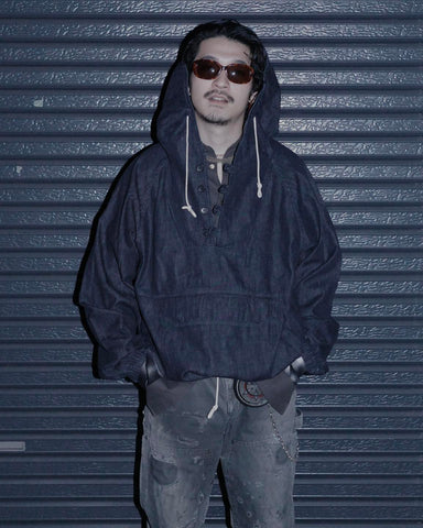 フード口のボタンの開閉により、首まわりのニュアンスを変えて楽しめる一着。素材には、経糸にコットンムラ糸、緯糸に綿麻混紡糸を使用した綿麻6ozデニムを採用しました。シャープなムラ感とリネン混ならではの粗野な風合いが、ヴィンテージの魅力を引き立てます。バイオウォッシュ加工を施すことで、使い始めから体に馴染む柔らかな質感に仕上げました。

A versatile piece featuring adjustable hood buttons to create a clean or relaxed neckline. Crafted from 6oz cotton-linen denim, the fabric combines sharp slub textures with the rustic feel of linen for an authentic vintage character. Treated with a bio-wash process, this INDIGO garment offers a soft, lived-in feel from the very first wear.