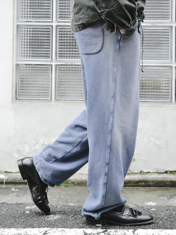 フロントにタックを施し、腰まわりにゆとりをもたせたスウェットパンツ。低速で丁寧に編み立てた30/10裏毛を使用し、ドライな質感と程よいハリ・コシを実現しました。硫化染め後、水を使用しないサスティナブルブリーチとダメージ加工を施すことで、環境に配慮しながら、長年の着用と日焼けによるヴィンテージの風合いをリアルに表現しています。
Sweatpants featuring front tucks for a relaxed waist silhouette. Crafted from 30/10 French Terry for a dry, structured touch, this BLUE pair undergoes a waterless sustainable bleach and damage process. It authentically recreates the sun-faded look of a vintage favorite while minimizing environmental impact.