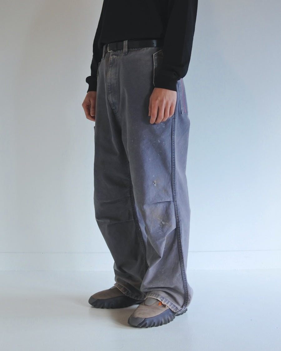 フラップポケットや膝のタック、裾のドローコードなど、ミリタリーのディテールをふんだんに取り入れた一本。内側に配置されることの多いポケットをあえて外側に設けたカーゴポケットが特徴です。ムラ糸で織り上げたバックサテン生地は、ハリとコシのある質感が魅力。さらに、水や薬品の使用を抑えながら生地の凹凸を際立たせる特殊エイジング加工を施し、深みのあるネイビーカラーに仕上げています。