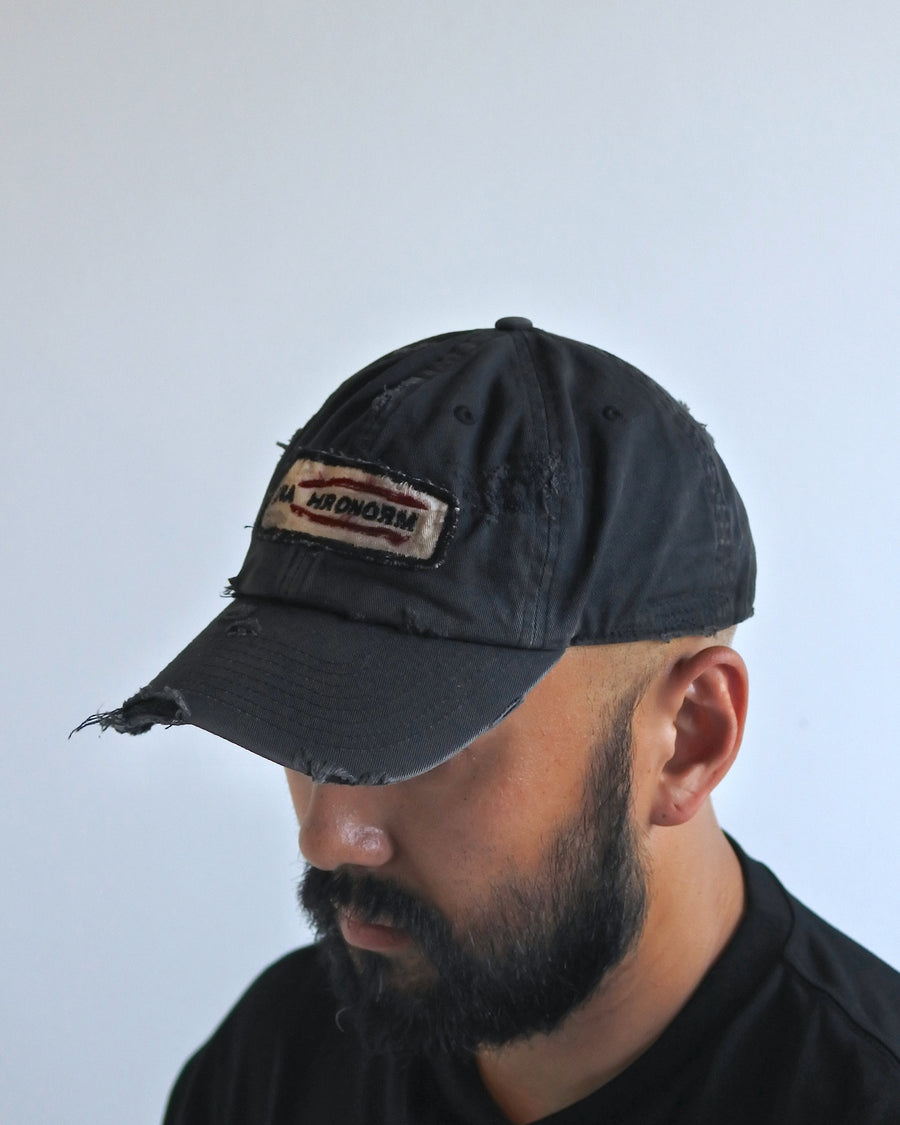 ダメージ加工とステッチ補強で、長年使い込まれた風合いを表現したキャップ。オリジナルワッペンにも同様の加工を施し、全体の統一感を高めました。素材には先染めのピグメントコットンキャンバスを採用。実用性とヴィンテージな佇まいを兼ね備え、スタイリングにこなれたアクセントを添える一着に仕上げています。

A distressed cap featuring reinforced stitching for a rugged, time-worn look. Both the body and the original patch are meticulously aged for a cohesive vintage aesthetic. Crafted from pre-dyed pigment cotton canvas, this BLACK piece combines durability with a sophisticated, lived-in feel, perfect for adding character to any outfit.
