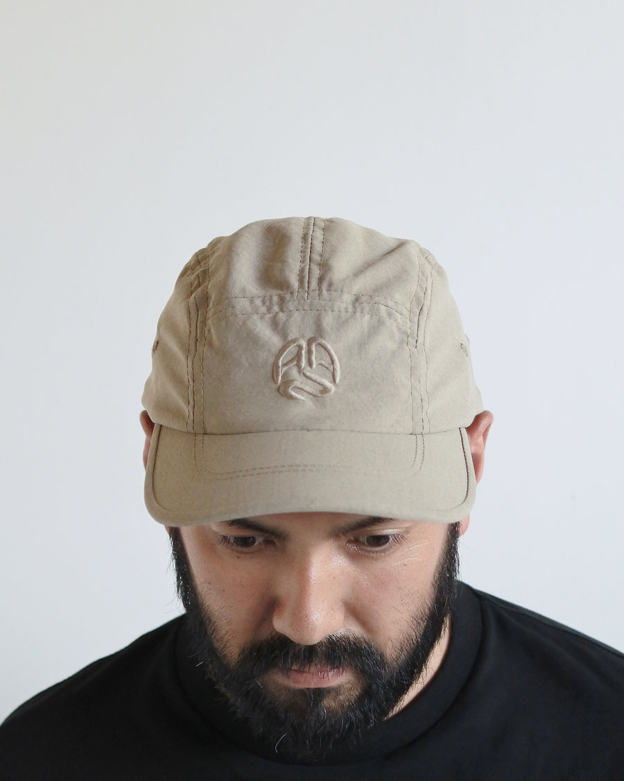 綿のような質感と軽量性を備えた高機能なポリエステルオックスを採用。タスラン加工糸により、シワになりにくく速乾性に優れたイージーケア性を実現しました。染色が困難なポリエステルに特殊顔料染めを施すことで、光沢を抑えたナチュラルで奥行きのある表情に。裏地にはサステナブルなリサイクルメッシュを使用し、快適な着用感にもこだわりました。

High-performance polyester oxford with a cotton-like touch, offering quick-dry and wrinkle-resistant benefits. This GRAY BEIGE piece features a special pigment dye for a matte, faded texture, defying its synthetic roots. Lined with eco-friendly recycled mesh, it ensures breathability while maintaining a sophisticated, natural aesthetic.