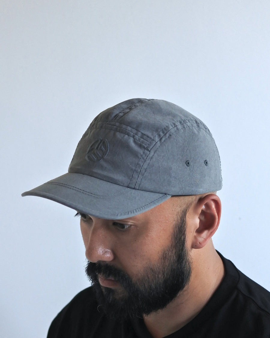 綿のような質感と軽量性を備えた高機能なポリエステルオックスを採用。タスラン加工糸により、シワになりにくく速乾性に優れたイージーケア性を実現しました。染色が困難なポリエステルに特殊顔料染めを施すことで、光沢を抑えたナチュラルで奥行きのある表情に。裏地にはサステナブルなリサイクルメッシュを使用し、快適な着用感にもこだわりました。

High-performance polyester oxford with a cotton-like touch, offering quick-dry and wrinkle-resistant benefits. This GRAY BLUE piece features a special pigment dye for a matte, faded texture, defying its synthetic roots. Lined with eco-friendly recycled mesh, it ensures breathability while maintaining a sophisticated, natural aesthetic.