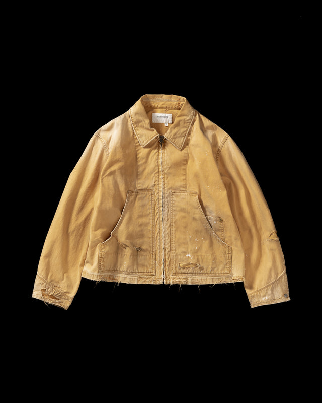 【 商品名：リメイクデトロイトダックジャケット 】

本製品は、ゆとりのある身幅とややクロップド丈に設計されたイエローカラーのジャケットで、インナーアイテムとのレイヤードを楽しめるバランスの良いシルエットが特徴です。生地には頒布の中でも最も薄手の11号帆布生地を使用しており、強度・耐久性に優れるとともに、着用を重ねるごとにアタリなどの経年変化を味わえる素材です。さらに、水や薬品の使用量を抑えながら生地の凹凸部分のアタリを強調し、同時に自然な脱色感を生み出す特殊エイジング加工を施し、加えてサンフェードによるダメージ加工も行うことで、より深みのある表情に仕上げています。