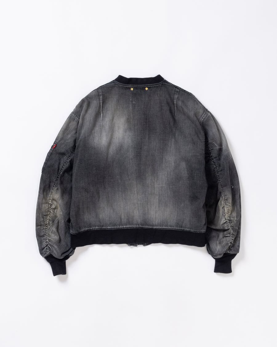 【 商品名：エイジングデュアルデニムMA-1 】

本製品は、ブランドのメイン素材であるデニムを使用し、ディティールを忠実に再現しながらシルエットを整えたブラックカラーのMA-1ジャケットです。中綿は入っていませんが、ライトオンスデニムを採用し、二重縫製によって柔らかく程よい肉感のある着心地に仕上げています。生地にはムラ糸を使用した8ozデニムを採用しており、シャープなムラ形状と粗野な風合いがより一層ヴィンテージ感を引き立てます。さらに加工には、全体にリアルなアタリ感を与えるエイジング加工を施し、深みのある表情を持たせています。