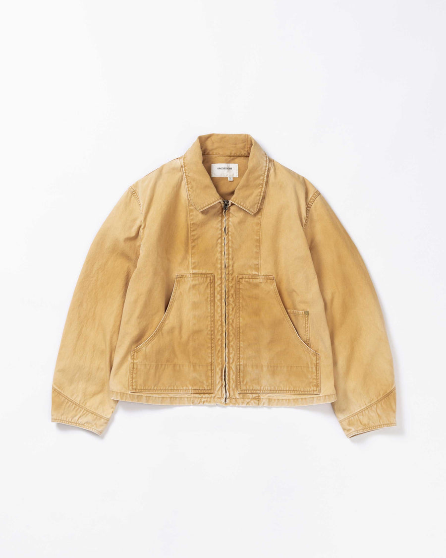 シルエットはゆとりのある身幅とややクロップド丈で設計しており、イエローカラーの鮮やかなトーンがレイヤードスタイルをより引き立てます。インナーアイテムとの重ね着がしやすいバランスに仕上げています。
生地には頒布の中で最も薄手の11号帆布を採用しており、強度・耐久性に優れるだけでなく、着用を重ねるごとにアタリなどの経年変化を楽しめる素材です。また、特殊エイジング加工を施すことで、水や薬品の使用量を抑えながら生地の凹凸が強調され、イエローの色味に自然なフェード感を加えています。