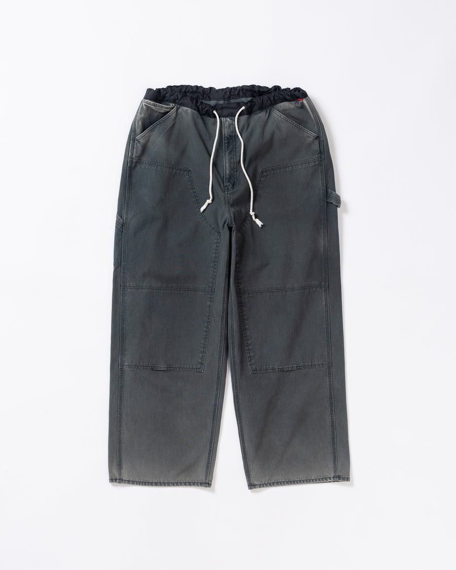 【 商品名：ダブルニーダックペインターパンツ 】

本製品は、レングスをやや長めに設定したブラックカラーのペインターパンツです。ウエスト部分にはナイロンオックス生地で切り替えを施し、ワーク感を抑えた上品なデザインに仕上げています。生地には頒布の中でも最も薄手の11号帆布生地を採用しており、強度・耐久性に優れるとともに、着用を重ねるごとにアタリなどの経年変化を楽しめる素材です。また、水や薬品の使用量を抑えながら生地の凹凸部分のアタリを強調し、同時に自然な脱色感を加える特殊エイジング加工を施しています。
