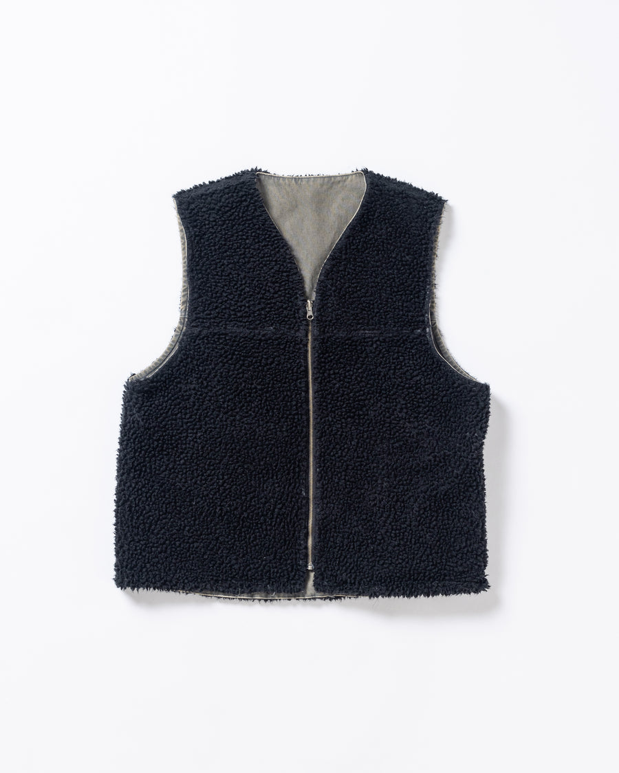 リバーシブルで着用が可能なダック×ボアのワークベスト。
カラーはブラック。
某ワークブランドよりも生地の重量が軽量なのでストレスの少ないライトな着用感も魅力的です。

■表地 : 11号帆布生地
頒布の中で最も薄手の11号を使用しており、強度・耐久性に優れ、着用を重ねるごとにアタリなどの経年変化を感じられる素材です。
■裏地 : シープボア
毛足がありながら、ざらつきが少ないソフトなボア生地です。

■加工 : 特殊エイジング加工/サンフェードダメージ加工
水や薬品の使用量を軽減させながら生地の凹凸部分のアタリを強調させ、同時に脱色させる特殊加工です。
さらにダメージ加工を施しております。