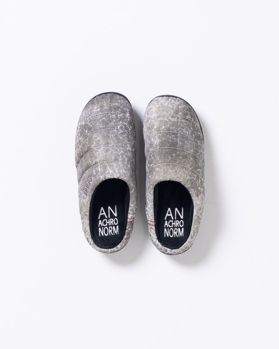 リラックスサンダル〈SUBU〉とのコラボレーションによって生まれた、特別仕様のフットギア。
アッパーにはANACHRONORMが独自の加工を施したナイロンオックスを採用。
染料の濃度や色味を幾度も検証し、洗いをかけることで偶発的なムラや陰影が生まれ、ひとつひとつランダムな表情を持つ一足が完成しました。
ふんわりと包み込む起毛ライニングと4層構造のインソールが、ダウンのようなぬくもりと心地よい弾力を生み出します。
SUBUの機能性にANACHRONORMのクラフト感が融合した、冬の定番を新たに更新する一足です。
カラーはホワイト。