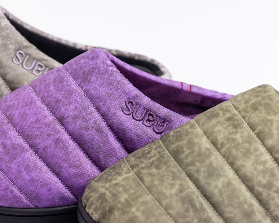 リラックスサンダル〈SUBU〉とのコラボレーションによって生まれた、特別仕様のフットギア。
アッパーにはANACHRONORMが独自の加工を施したナイロンオックスを採用。
染料の濃度や色味を幾度も検証し、洗いをかけることで偶発的なムラや陰影が生まれ、ひとつひとつランダムな表情を持つ一足が完成しました。
ふんわりと包み込む起毛ライニングと4層構造のインソールが、ダウンのようなぬくもりと心地よい弾力を生み出します。
SUBUの機能性にANACHRONORMのクラフト感が融合した、冬の定番を新たに更新する一足です。
カラーはパープル。