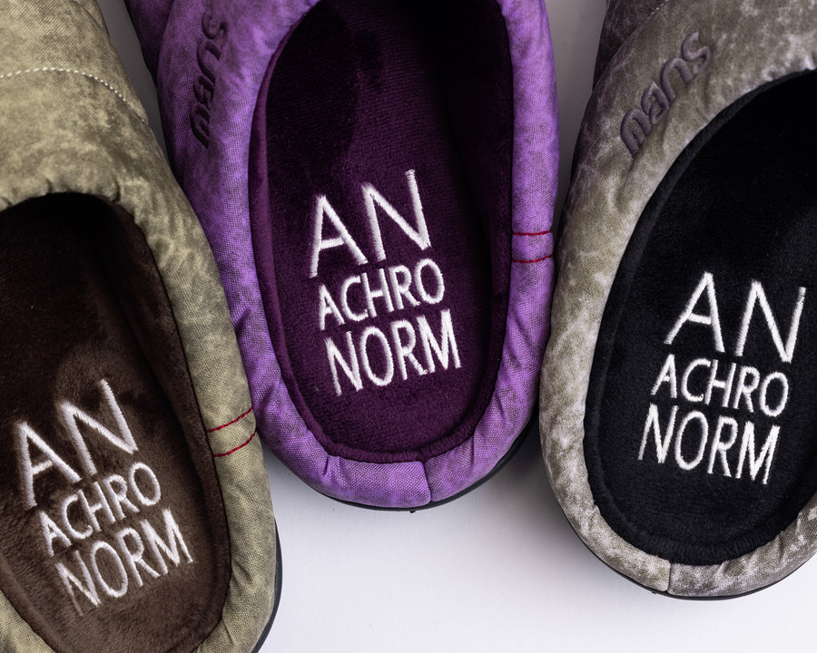 リラックスサンダル〈SUBU〉とのコラボレーションによって生まれた、特別仕様のフットギア。
アッパーにはANACHRONORMが独自の加工を施したナイロンオックスを採用。
染料の濃度や色味を幾度も検証し、洗いをかけることで偶発的なムラや陰影が生まれ、ひとつひとつランダムな表情を持つ一足が完成しました。
ふんわりと包み込む起毛ライニングと4層構造のインソールが、ダウンのようなぬくもりと心地よい弾力を生み出します。
SUBUの機能性にANACHRONORMのクラフト感が融合した、冬の定番を新たに更新する一足です。
カラーはパープル。